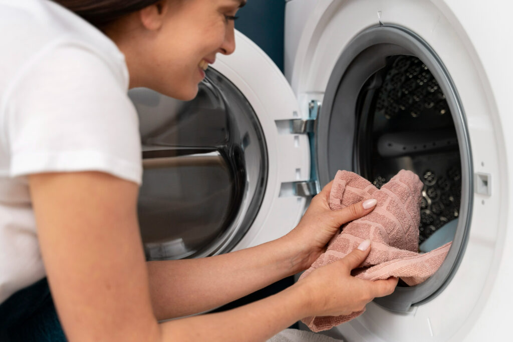 mujer limpiando un lavarropas