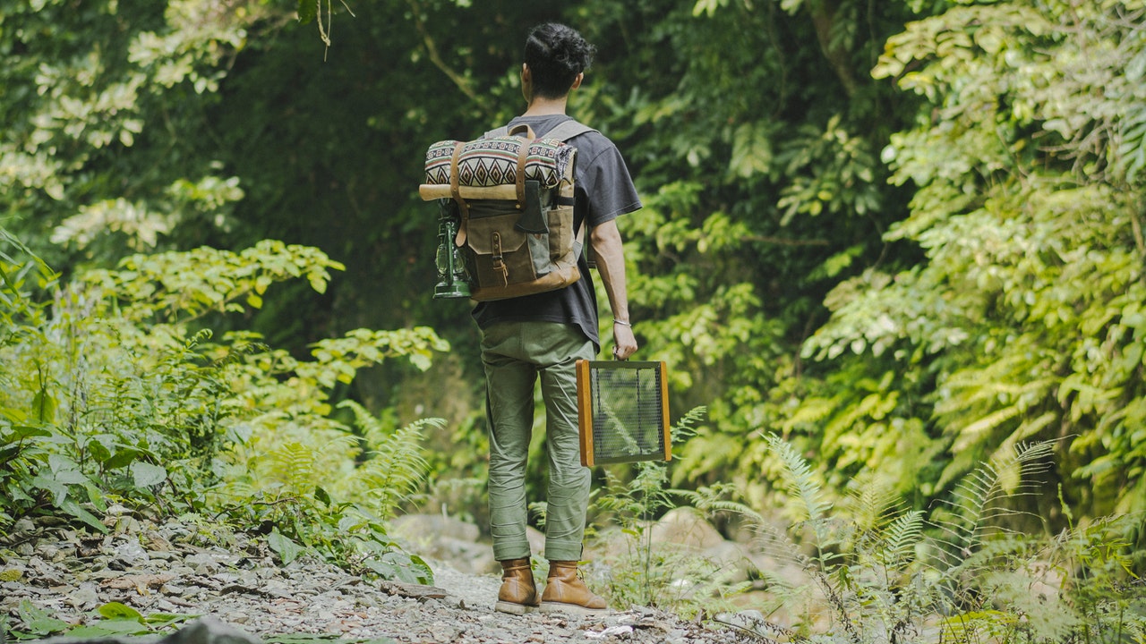 hombre con mochila recorriendo un bosque
