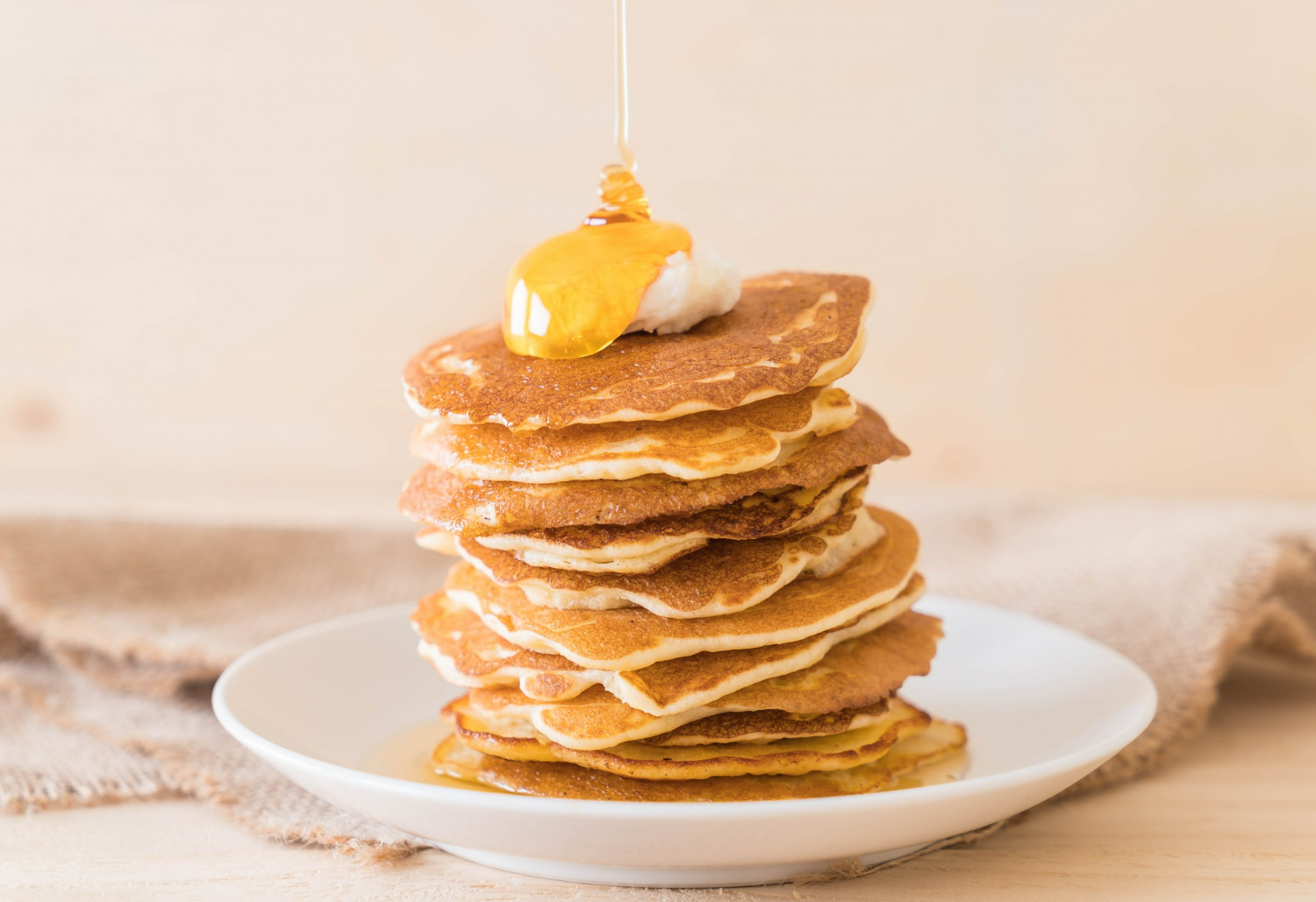 panqueques apilados en un plato con banana y miel